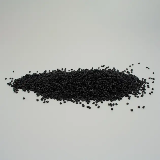 Granuli di plastica nera su uno sfondo bianco, utilizzati per vari progetti di lavorazione e produzione.