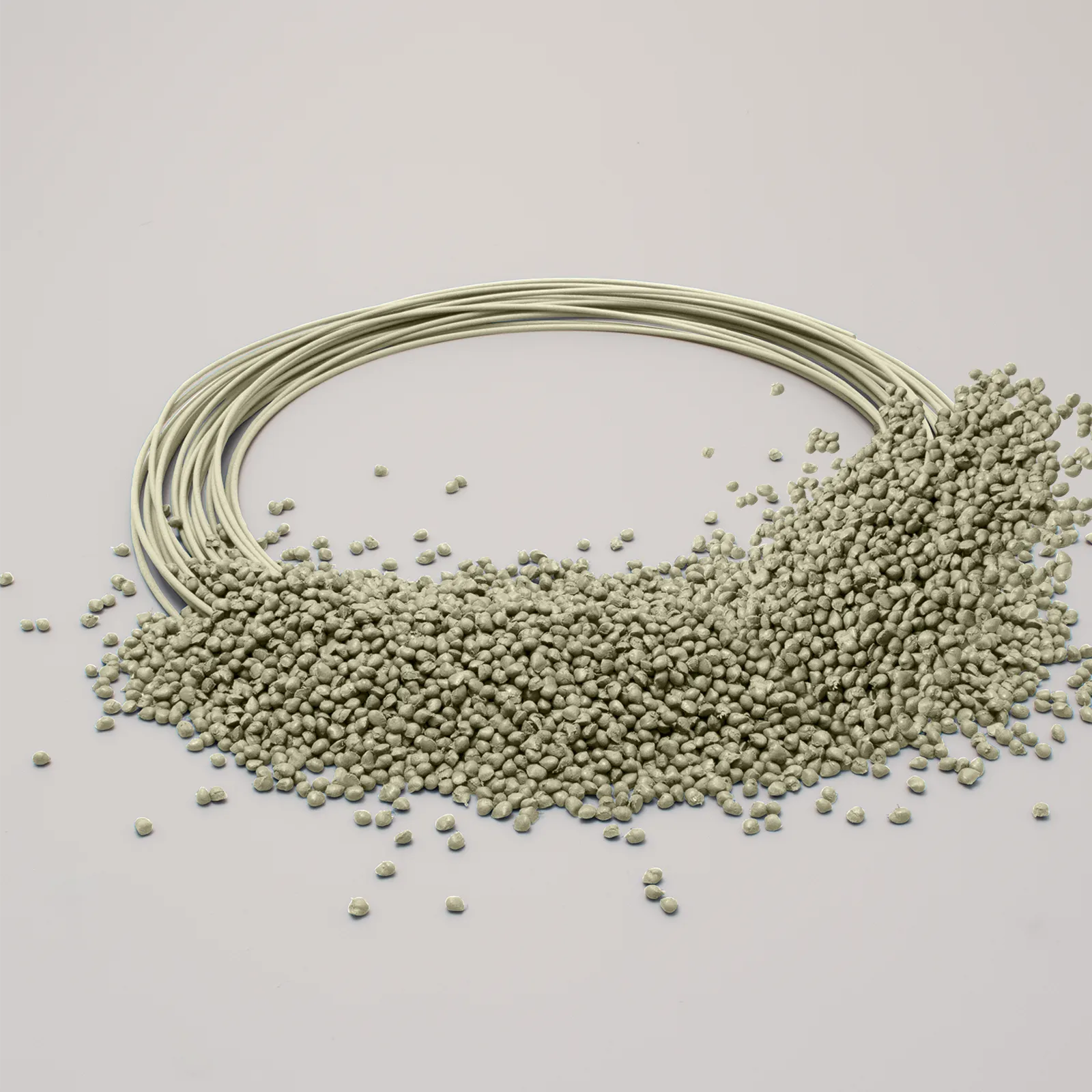 Beige plastic pellets scattered next to plastic filaments, on a light background